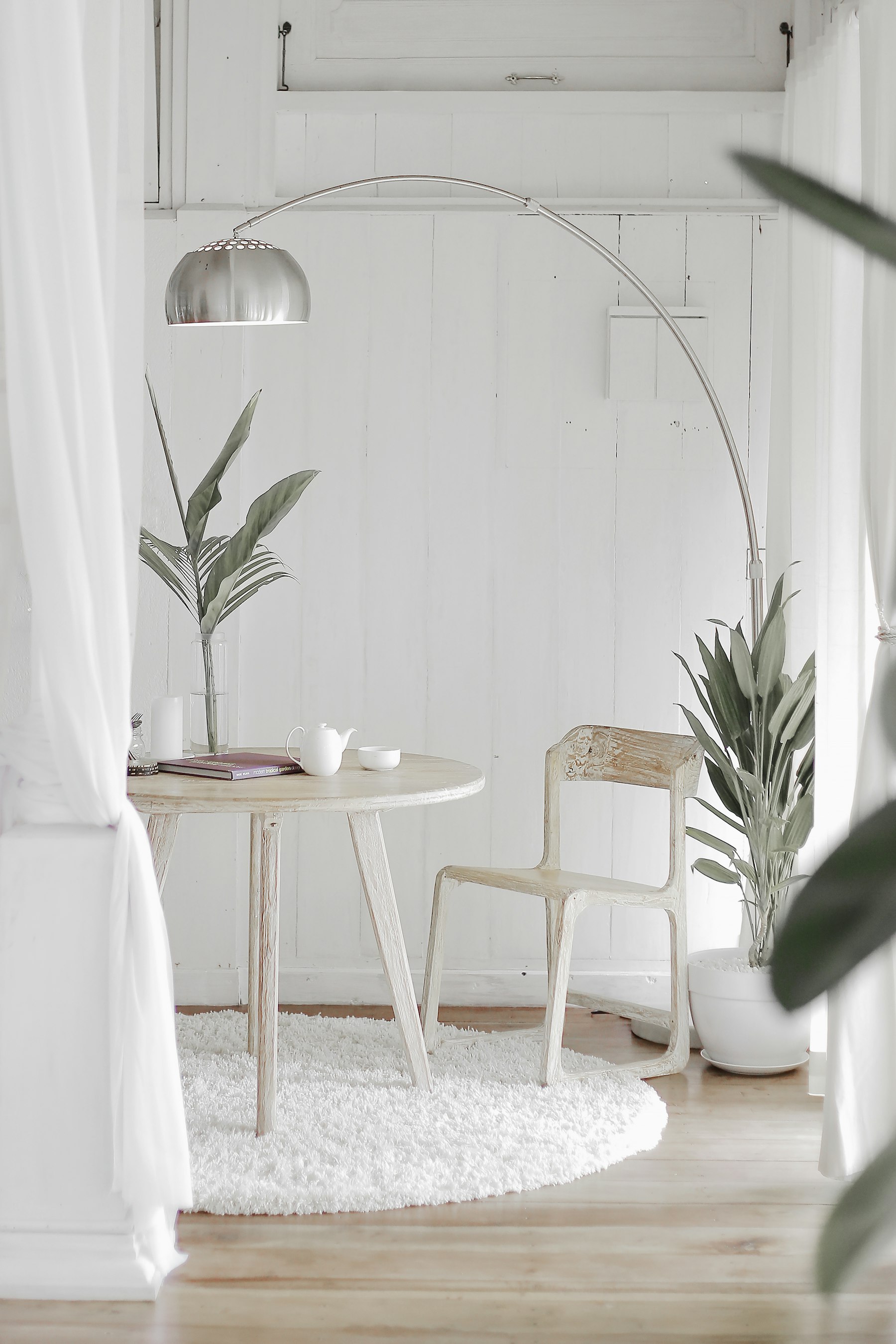 Reading corner with boucle chair, books, linen throw, and paper lamp