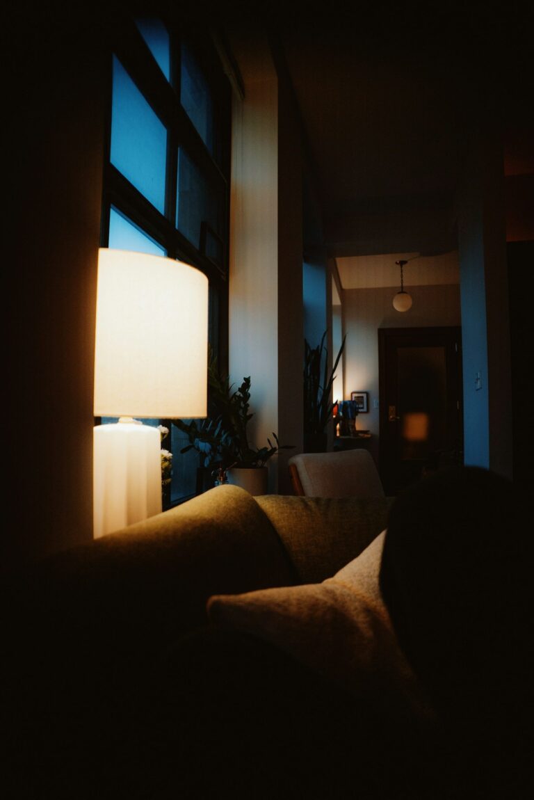 Living room lit after dark by a warm table lamp beside the sofa